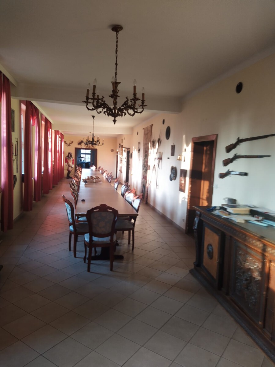 Historischer Flur mit langer Tafel, Kronleuchter und Waffensammlung im Berliner Herrenhaus